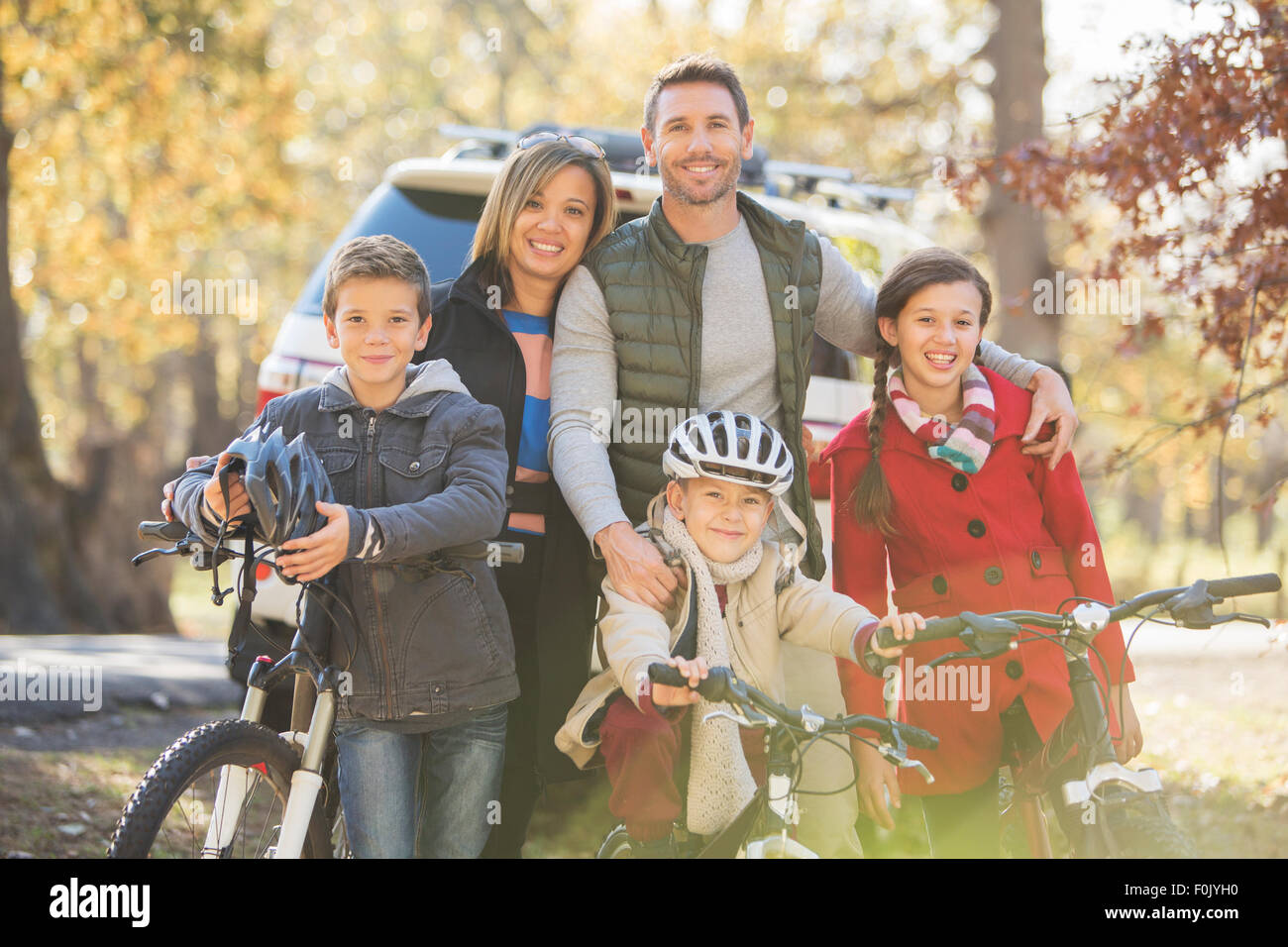 Portrait smiling family with bicycles outdoors Stock Photo