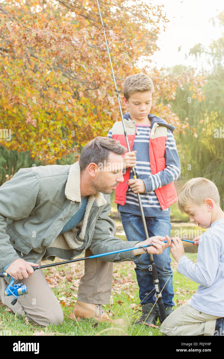 Father teaching sons to prepare fishing rods Stock Photo