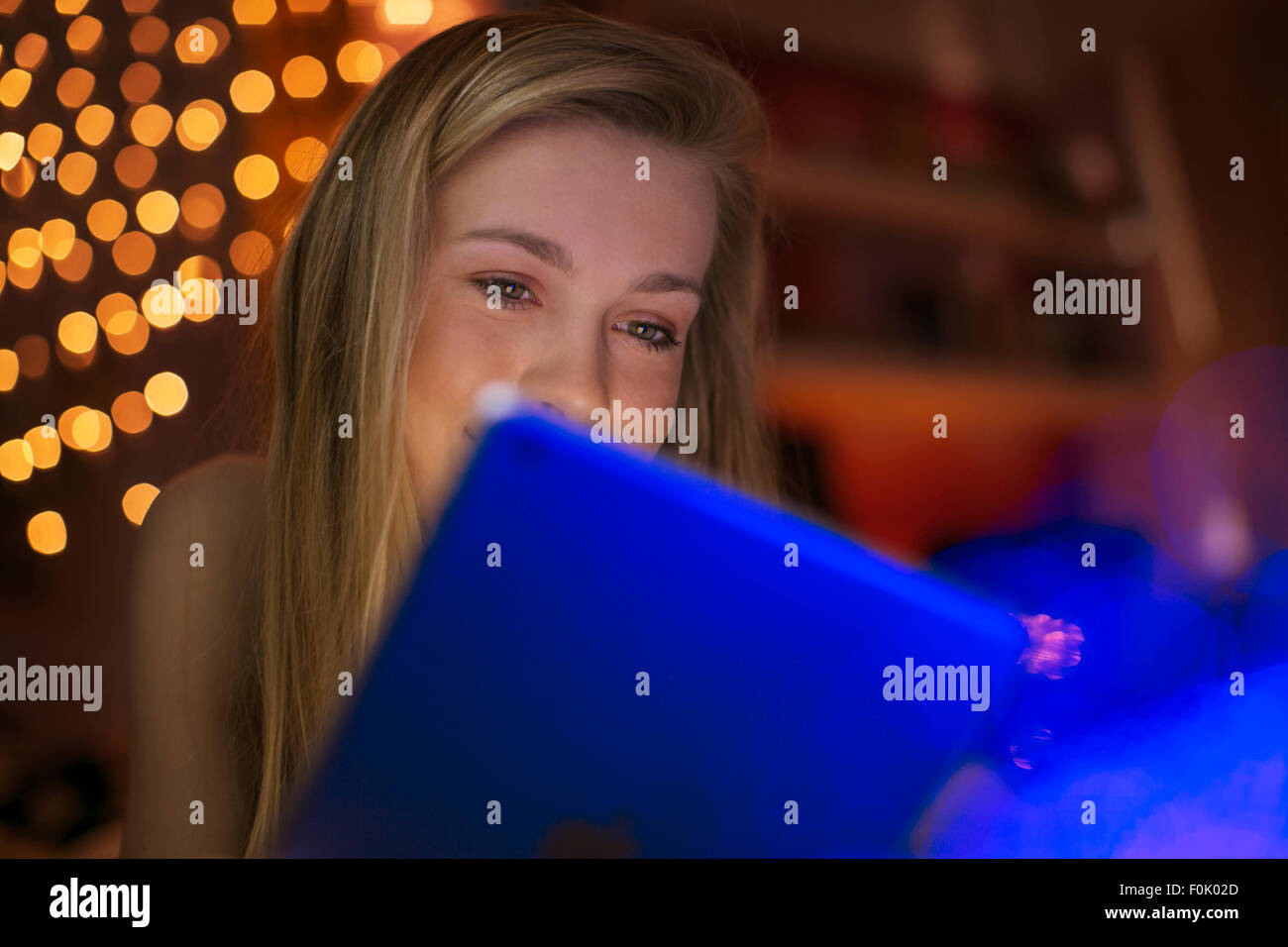 Teenage girl using digital tablet in dark room Stock Photo