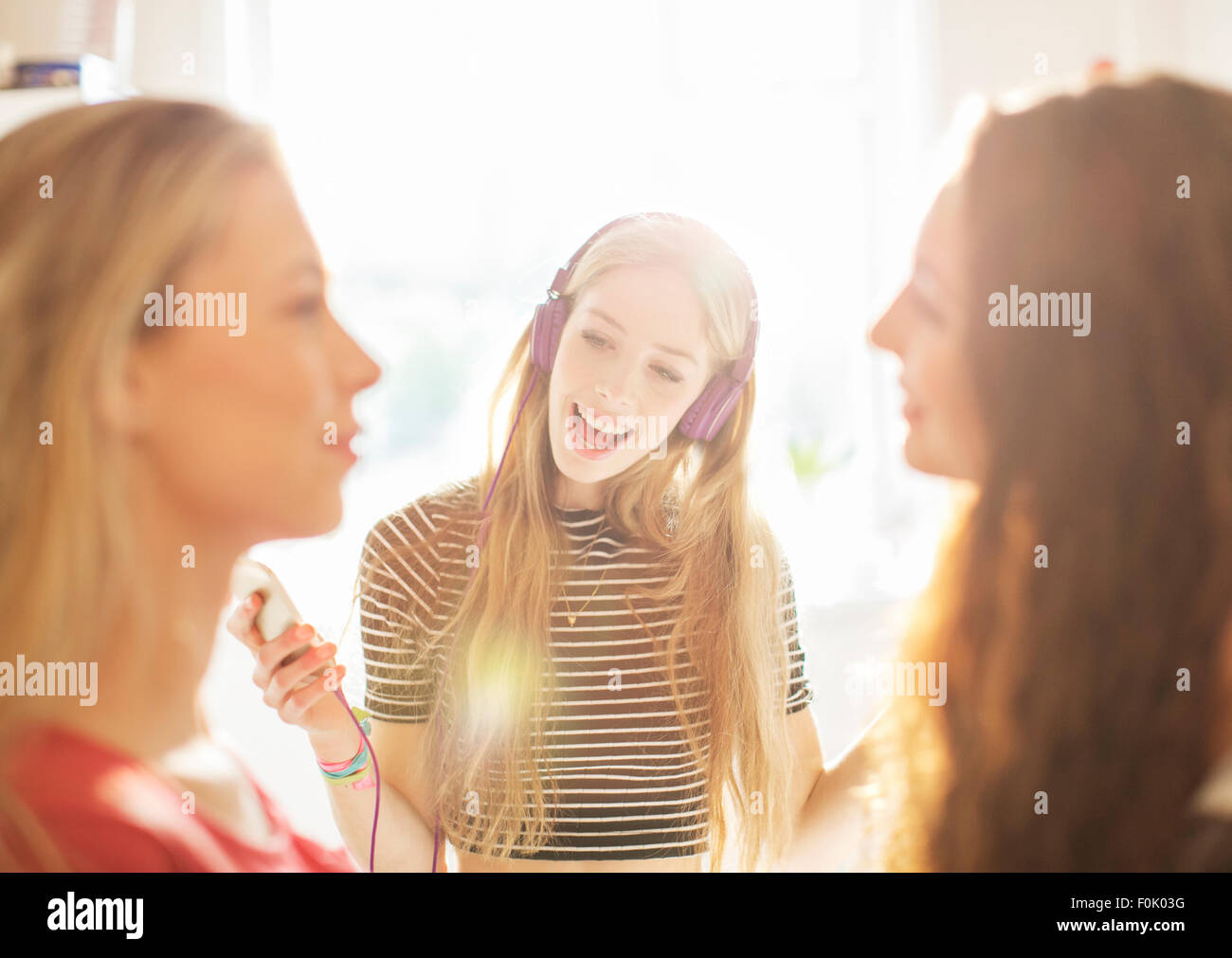 Teenage girls hanging out listening to music with headphones Stock Photo