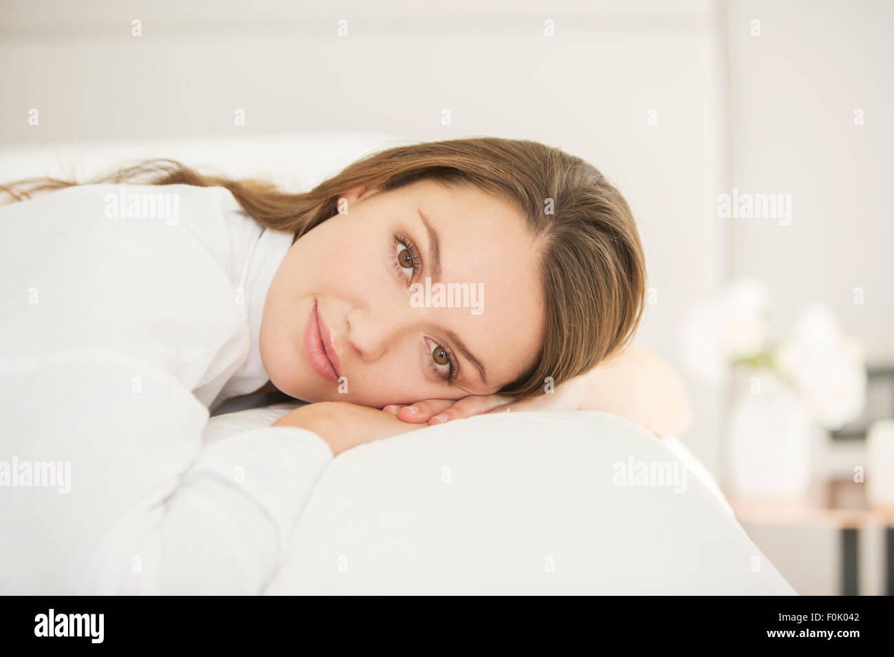 Portrait serene woman laying on bed Stock Photo