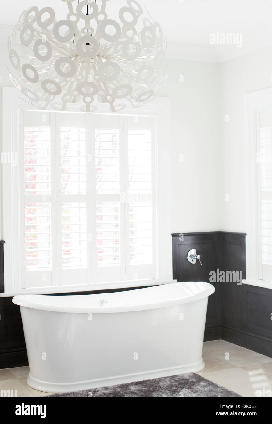 Soaking tub and modern chandelier in luxury bathroom Stock Photo
