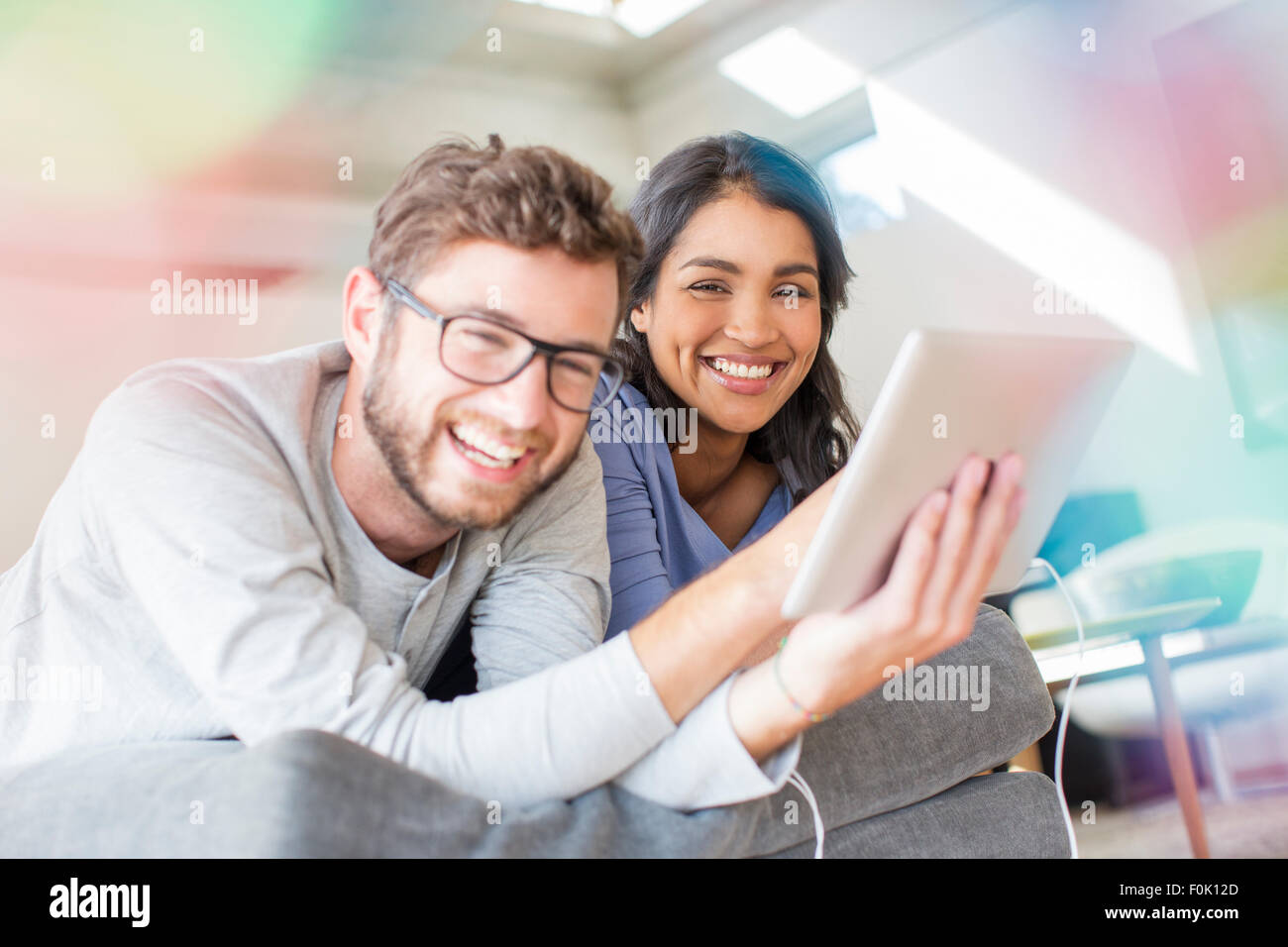 Portrait laughing couple using digital tablet Stock Photo