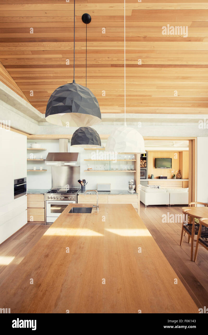 Modern pendant lights over long wood kitchen island Stock Photo