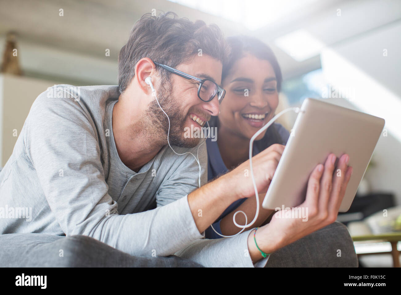 Smiling couple with headphones using digital tablet Stock Photo