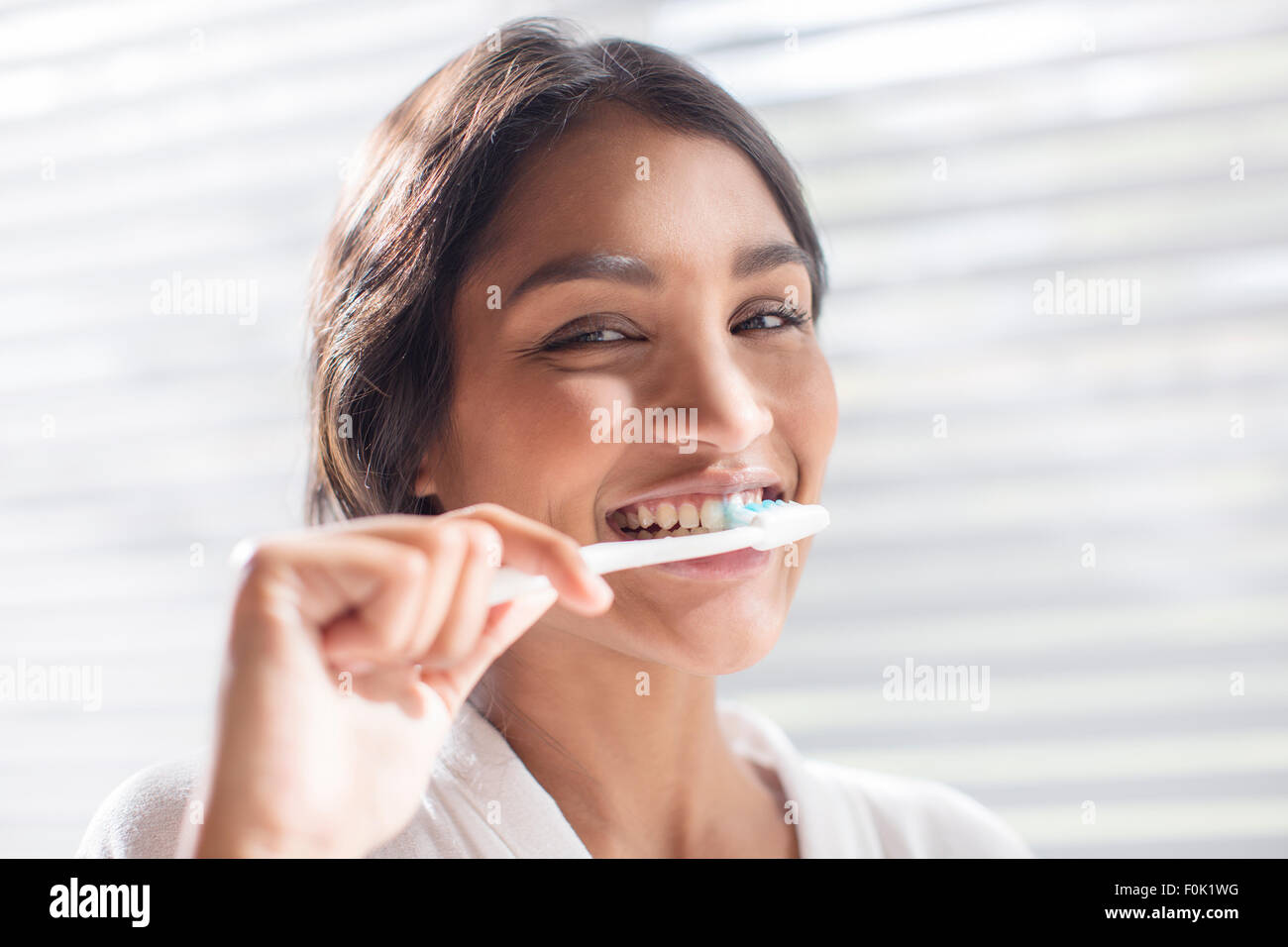 Close up portrait smiling woman brushing teeth Stock Photo