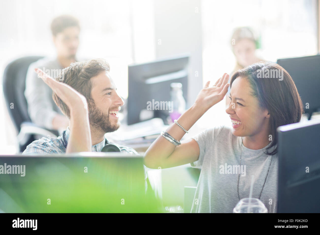 Enthusiastic business people high fiving in office Stock Photo