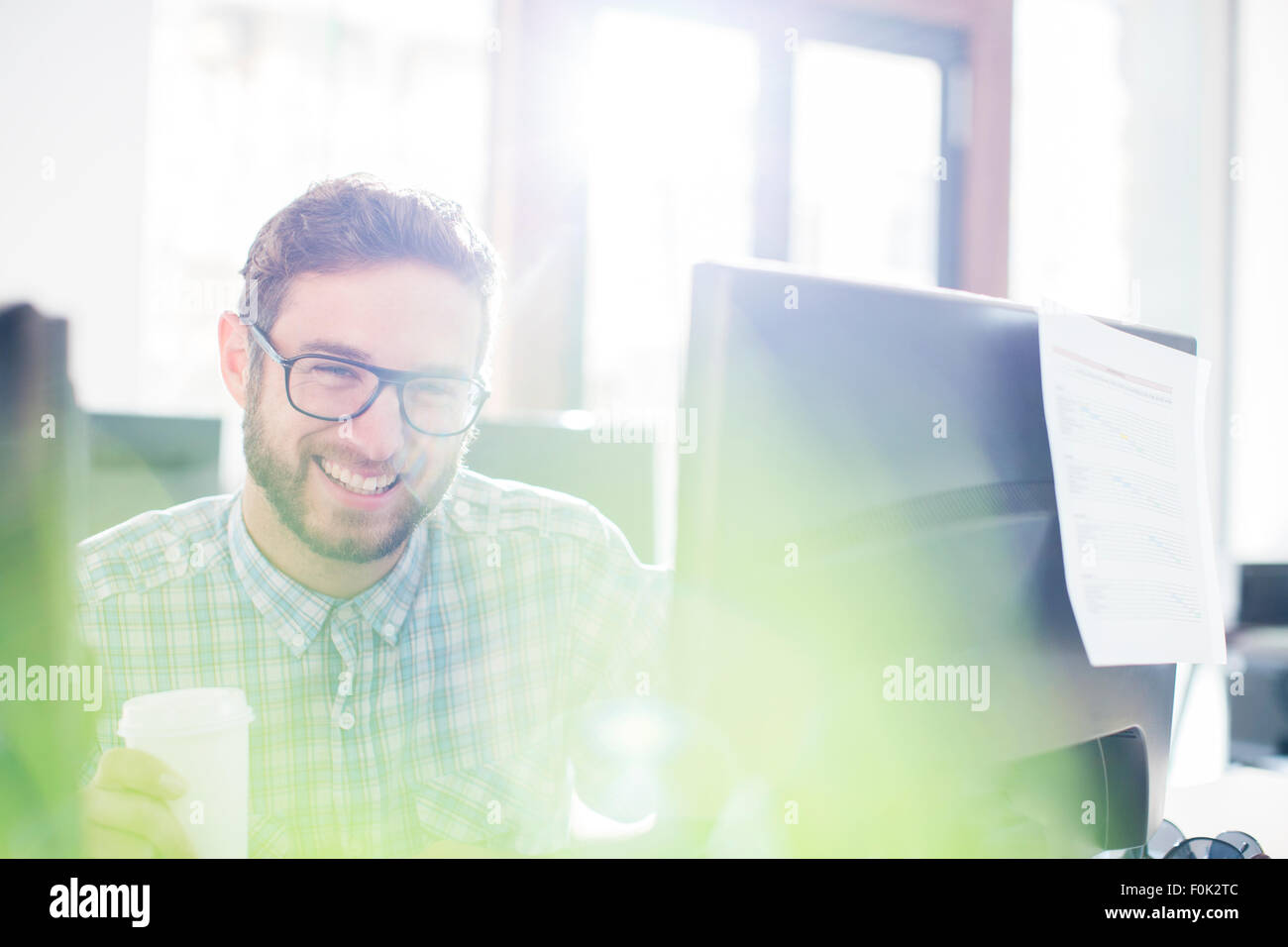 Portrait enthusiastic creative businessman drinking coffee at computer Stock Photo