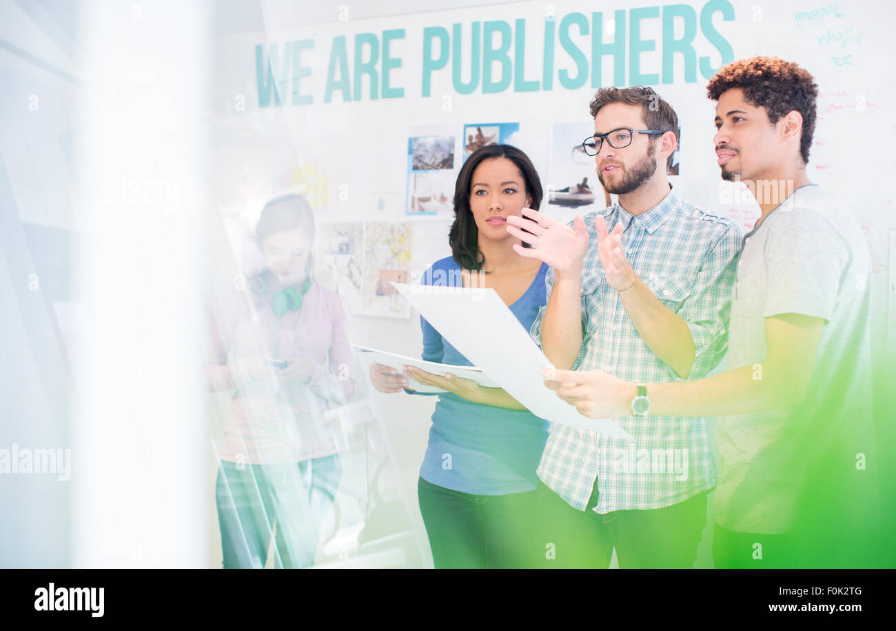 Publishers reviewing and discussing proofs in office Stock Photo