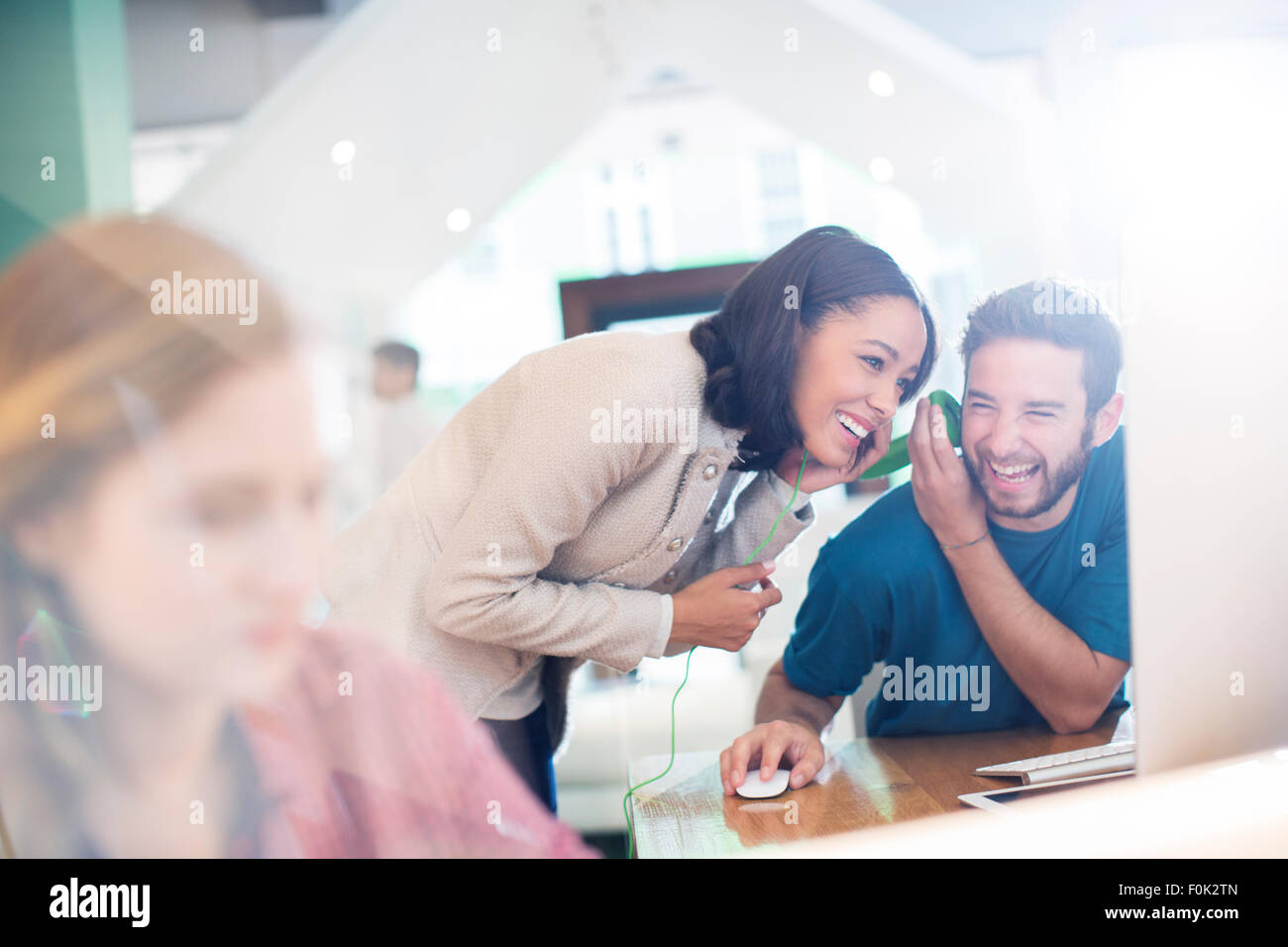 Creative business people sharing and listening to headphones in office Stock Photo