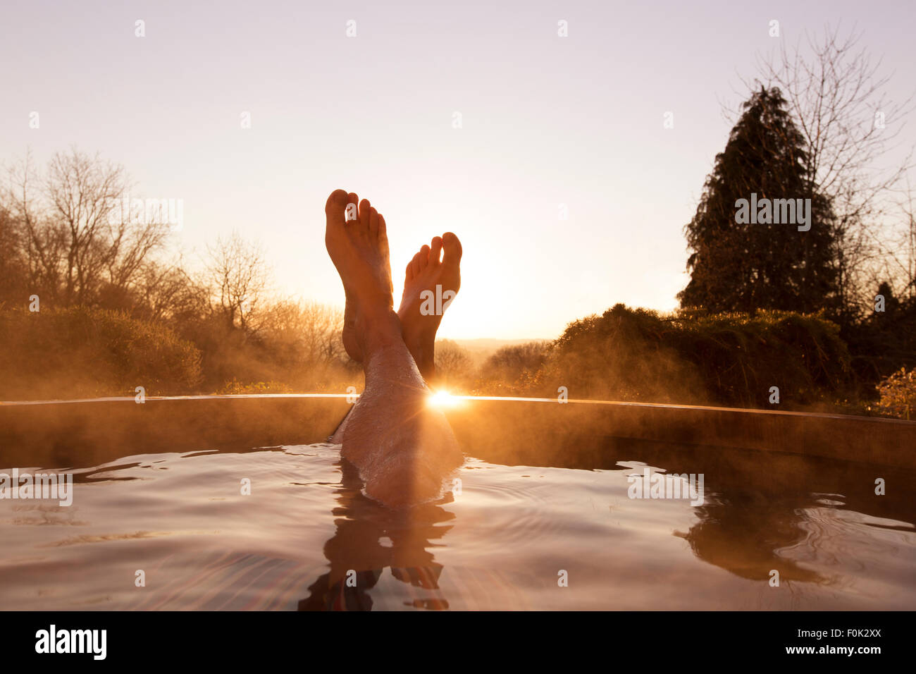 Man’s feet raised out of pool Stock Photo