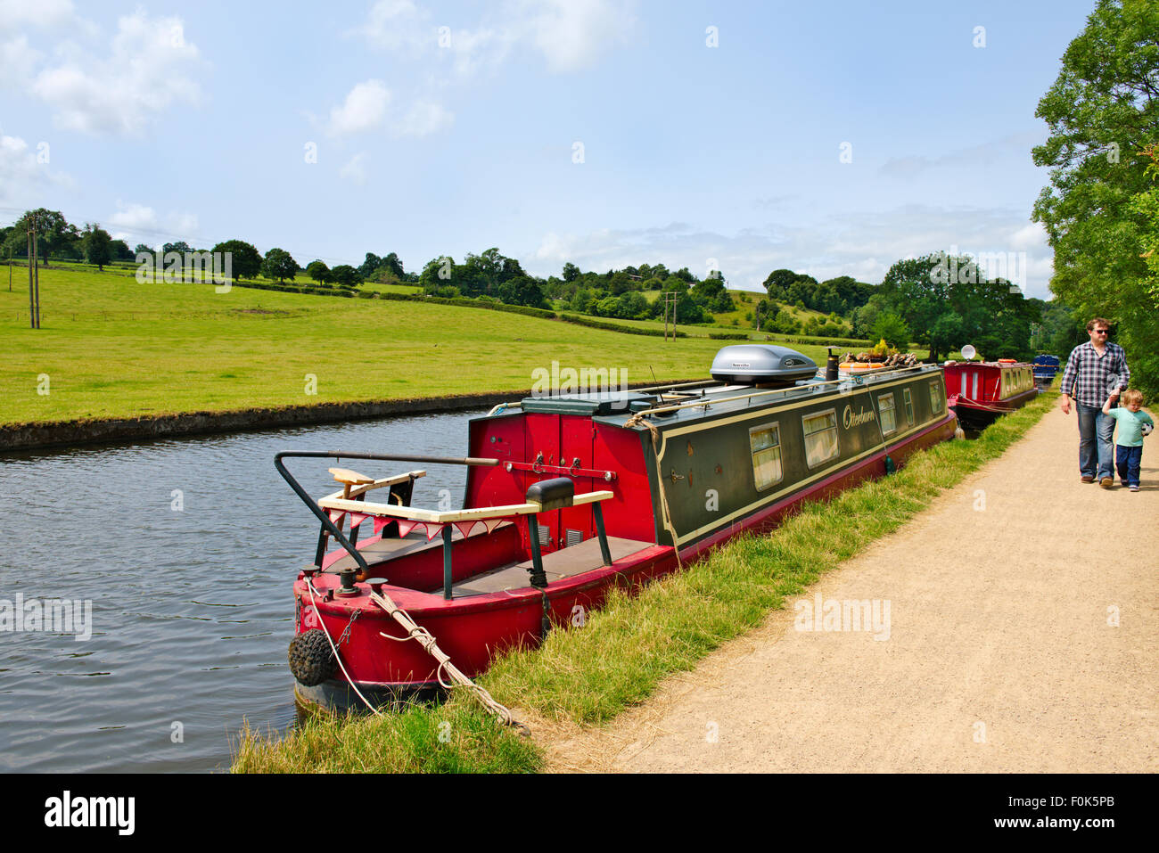 Father young son walking along Leeds and Liverpool canal tow-path on sunny summer day, near Calverley Bridge, West Yorkshire Stock Photo