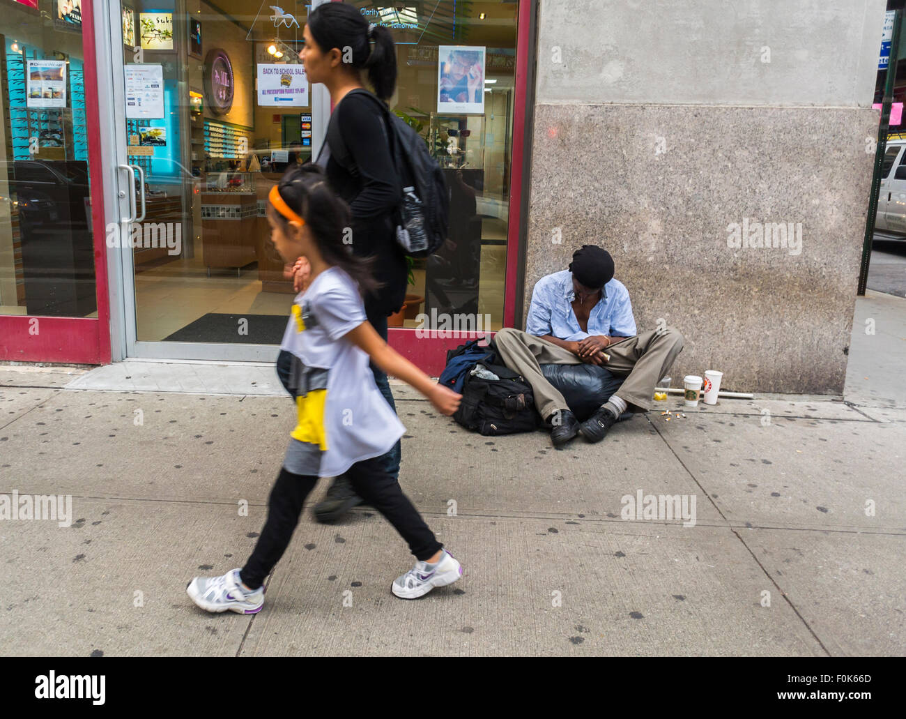 New York City, USA, Street Scenes, Chinatown District, Woman with Child, Walking by Homeless man sitting on sidewalk begging, social care crisis, poverty usa Stock Photo