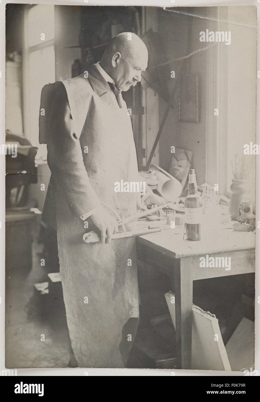 Akseli Gallen-Kallela in working clothes standing at his desk in Porvoo, 1923. Akseli Gallen-Kallela in working clothes standing at his desk in Stock Photo