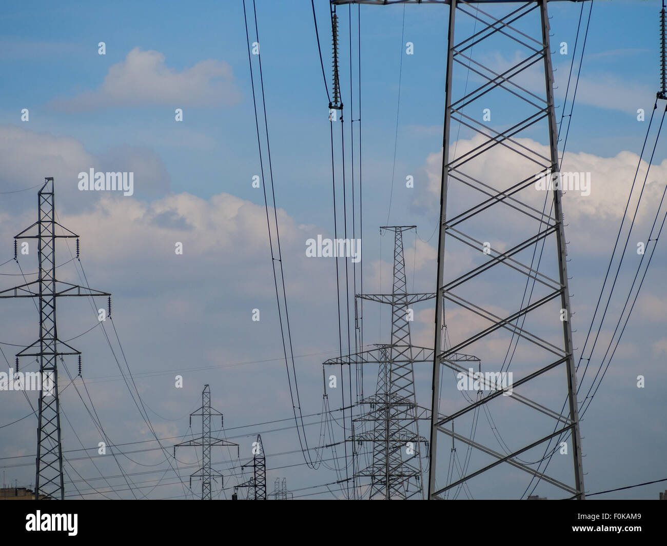 a high voltage power pylons against blue sky Stock Photo - Alamy