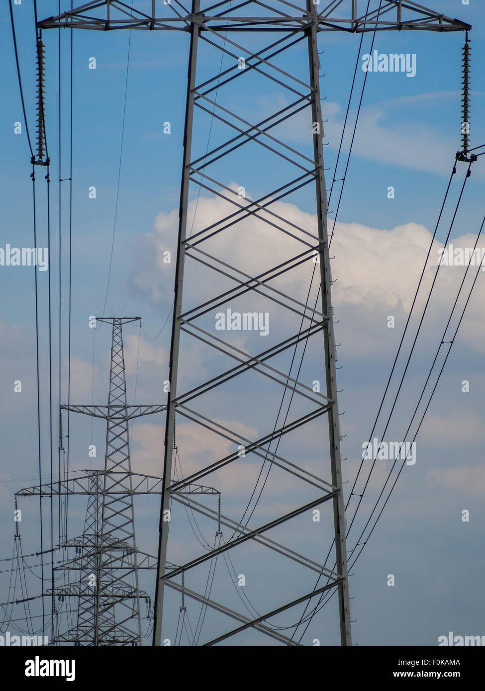 a high voltage power pylons against blue sky Stock Photo - Alamy