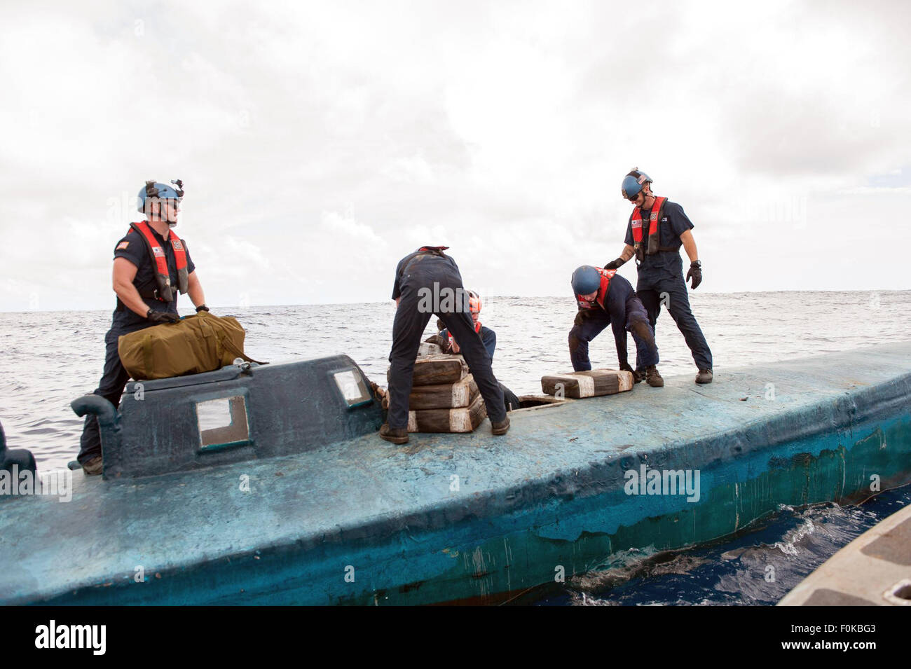 A US Coast Guard boarding team from the USCG Cutter Stratton removes bales of cocaine from a self-propelled semi-submersible submarine interdicted in international waters July 19, 2015 off the coast of Central America. Stock Photo