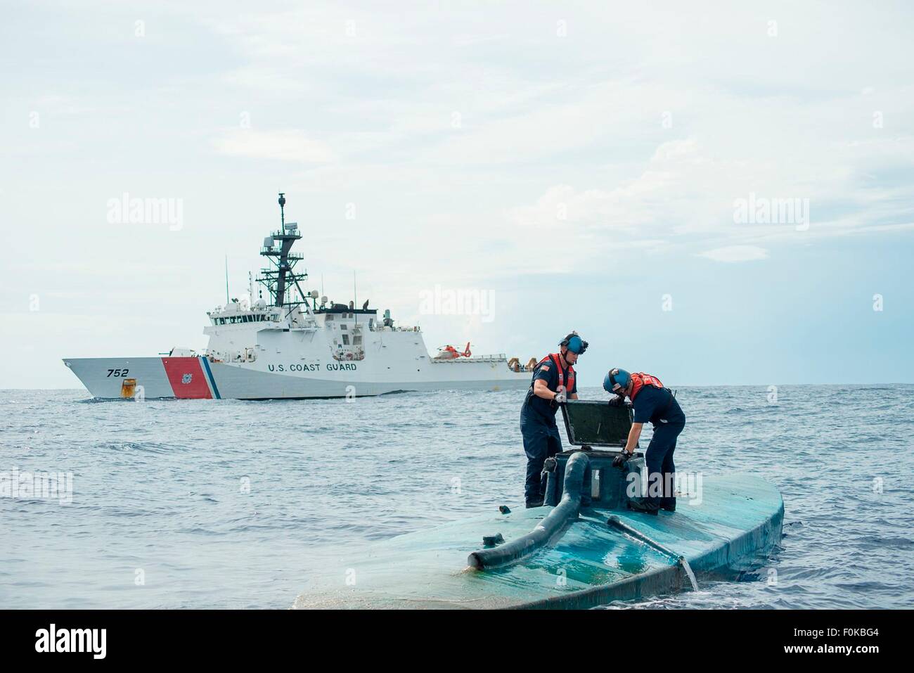 A US Coast Guard boarding team from the USCG Cutter Stratton investigates a self-propelled semi-submersible submarine carrying 6 tons of cocaine interdicted in international waters July 19, 2015 off the coast of Central America. Stock Photo