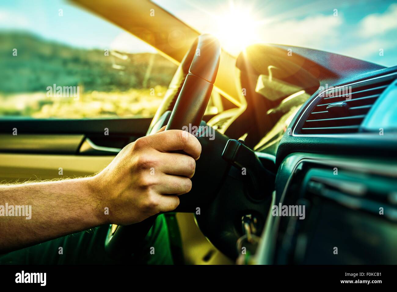 Summer Time Car Trip. Car Traveling. Men Driving Down the Road During Scenic Sunset. Stock Photo