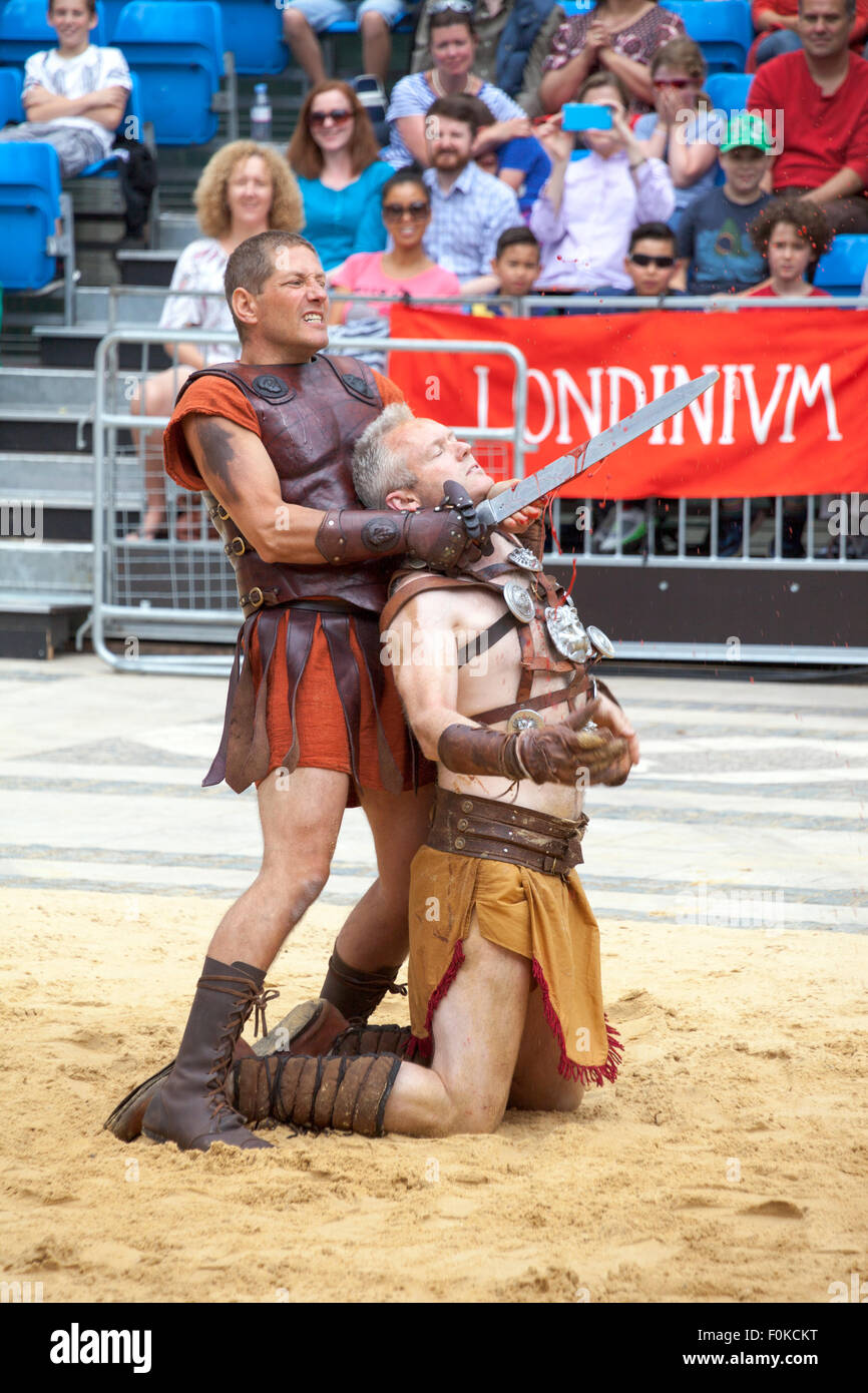 London, UK. 16th August, 2015. Live action Gladiator show at the Guildhall Yard. Professional gladiators battle it out in Guildhall Yard, the site of London's only Roman amphitheater. The reconstructions of the gladiator-style games once held in ancient Londinium took place before an emperor and cheerful crowd who decide which warrior will get to walk free based on their performance. Credit: Nathaniel Noir/Alamy Live News Stock Photo