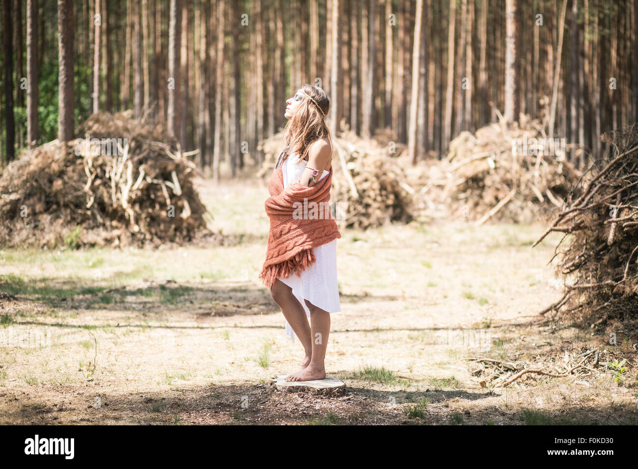 Young woman standing in the woods enjoying tranquility Stock Photo