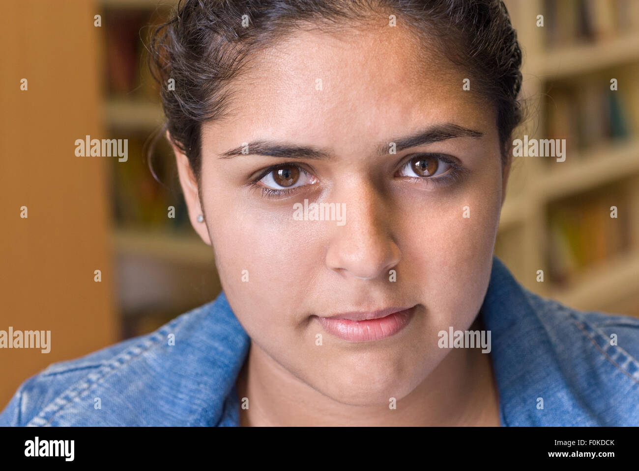 Close portrait of confident attractive senior teenage girl student in school library Stock Photo