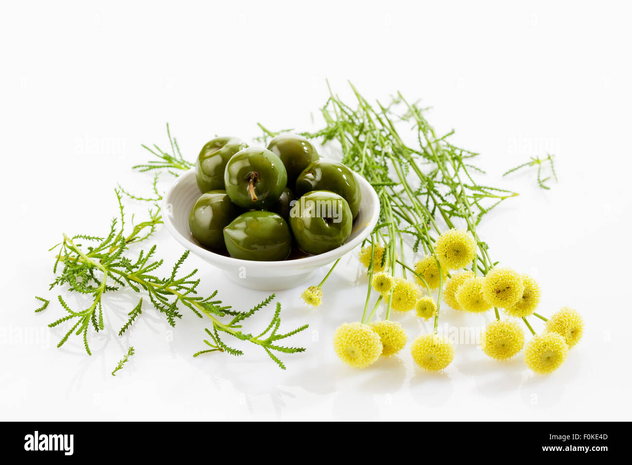 Bowl of green olives and green santolina Stock Photo