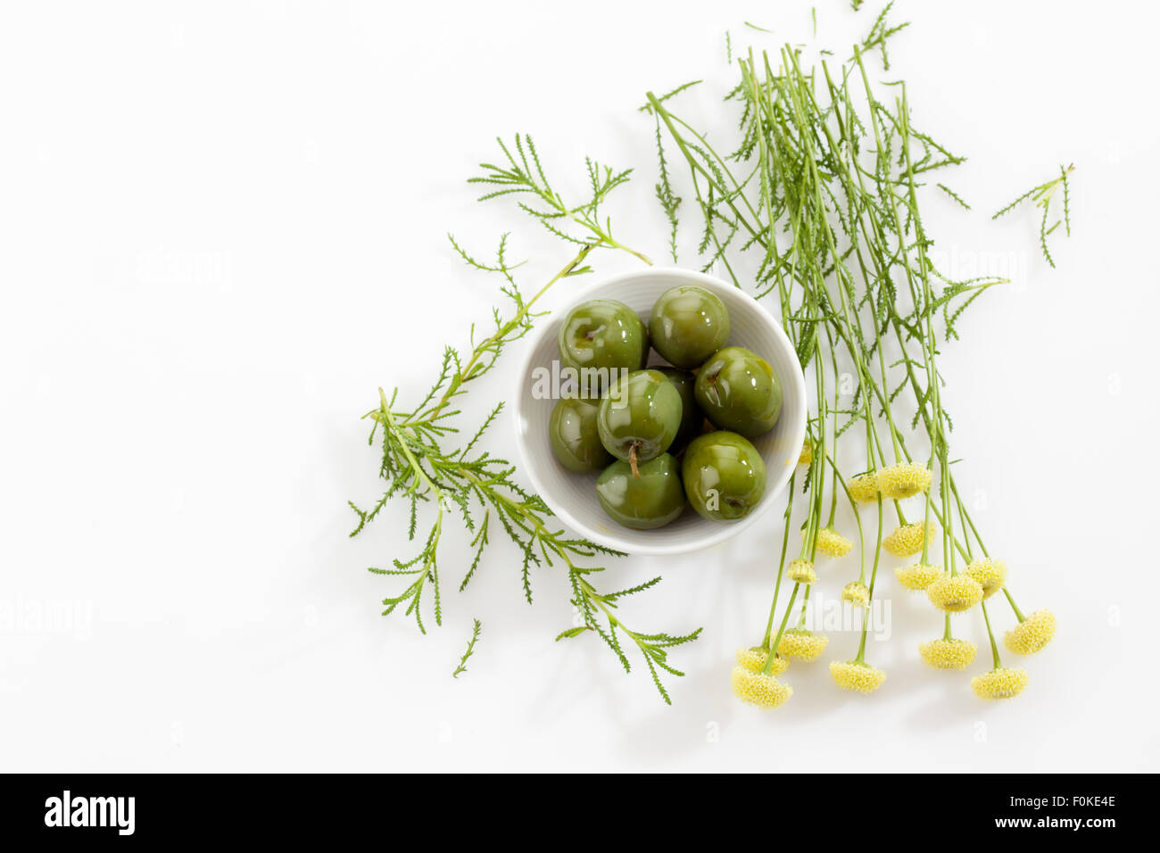 Bowl of green olives and green santolina Stock Photo