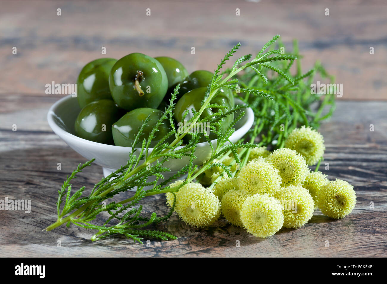 Bowl of green olives and green santolina Stock Photo