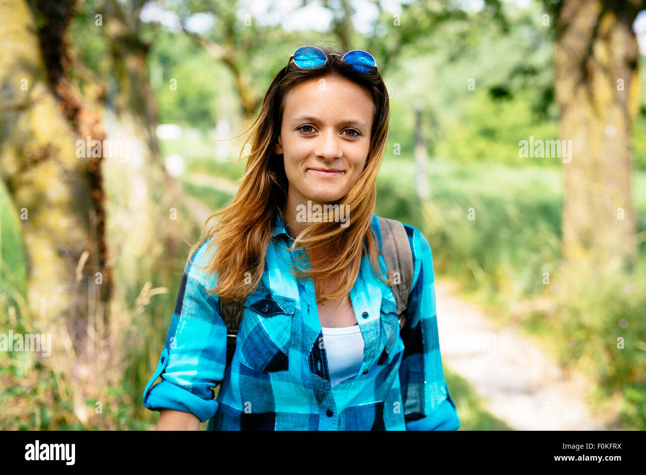 Portrait of smiling teenage girl hiking in the countryside Stock Photo ...