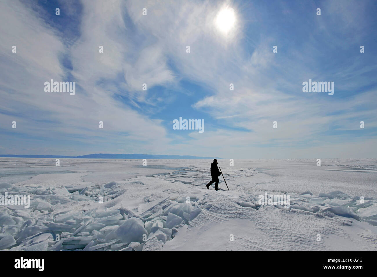 Russia, Lake Baikal, man walking on frozen lake Stock Photo