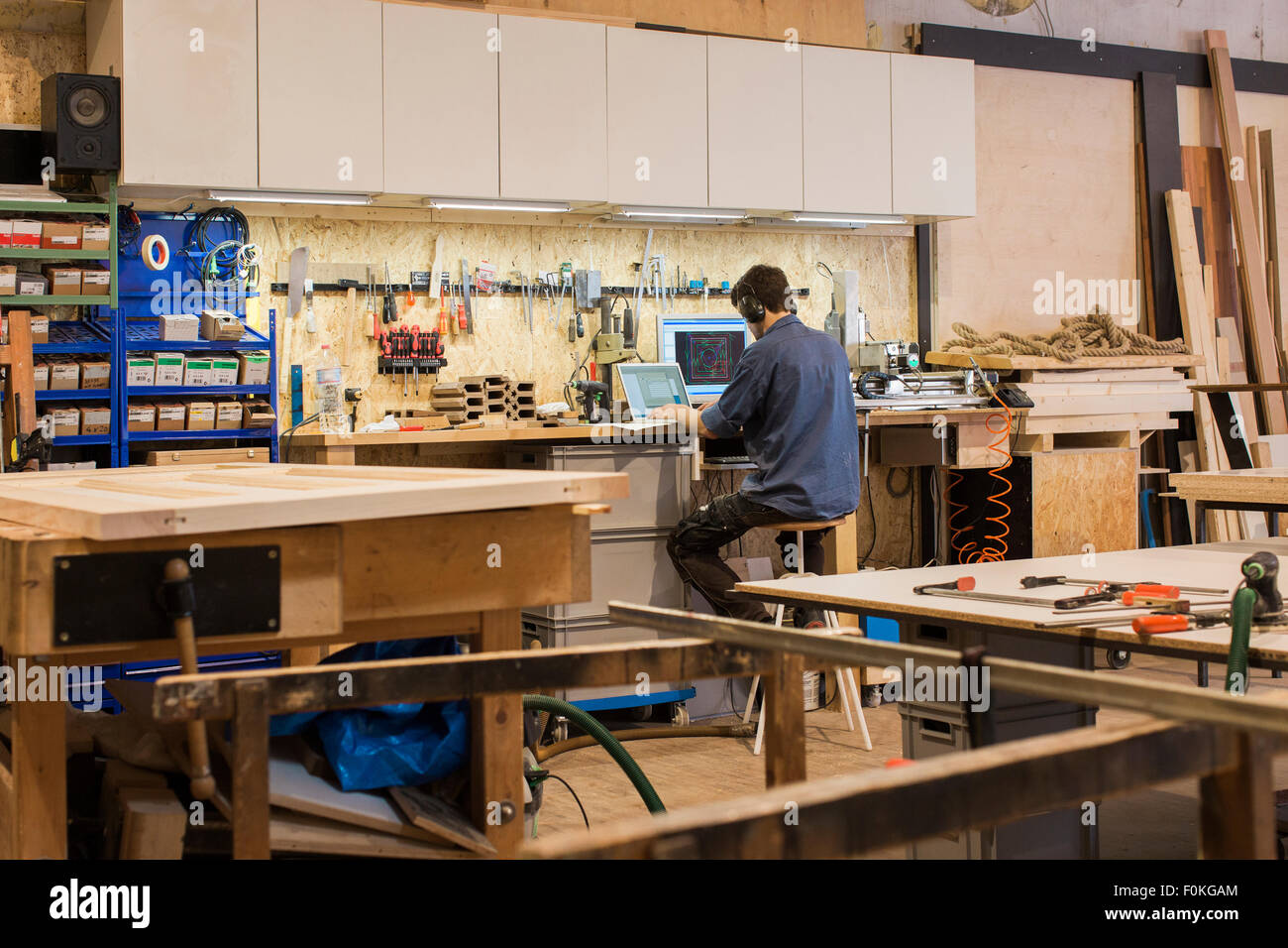 Carpenter working with computer in workshop Stock Photo - Alamy