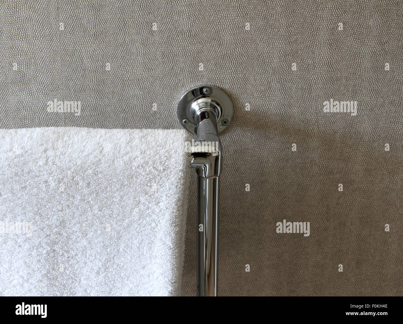 Heated towel rail on neutral wall covering Stock Photo