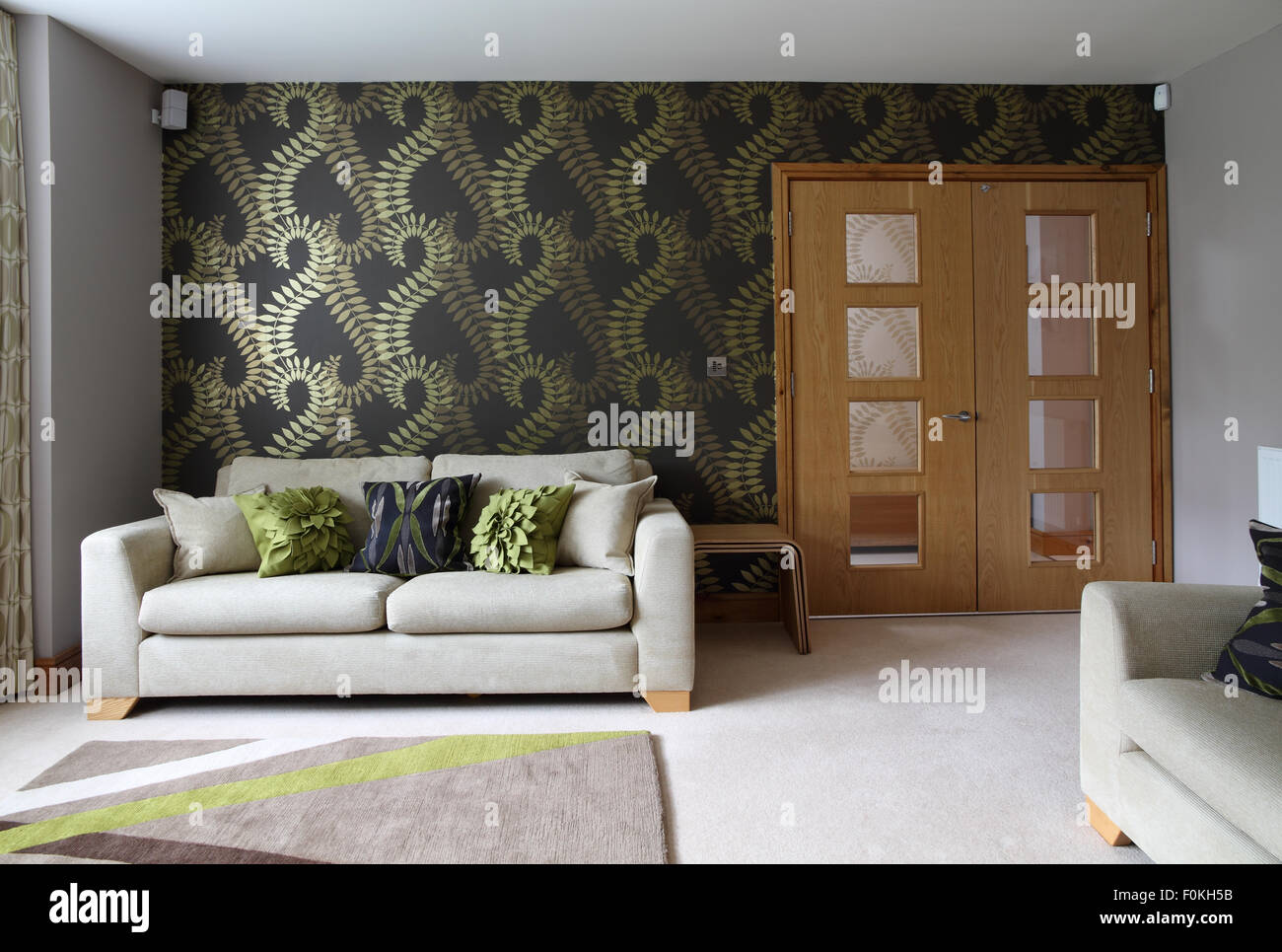 Modern living/sitting room with double doors, large print wallpaper and abstract rug Stock Photo