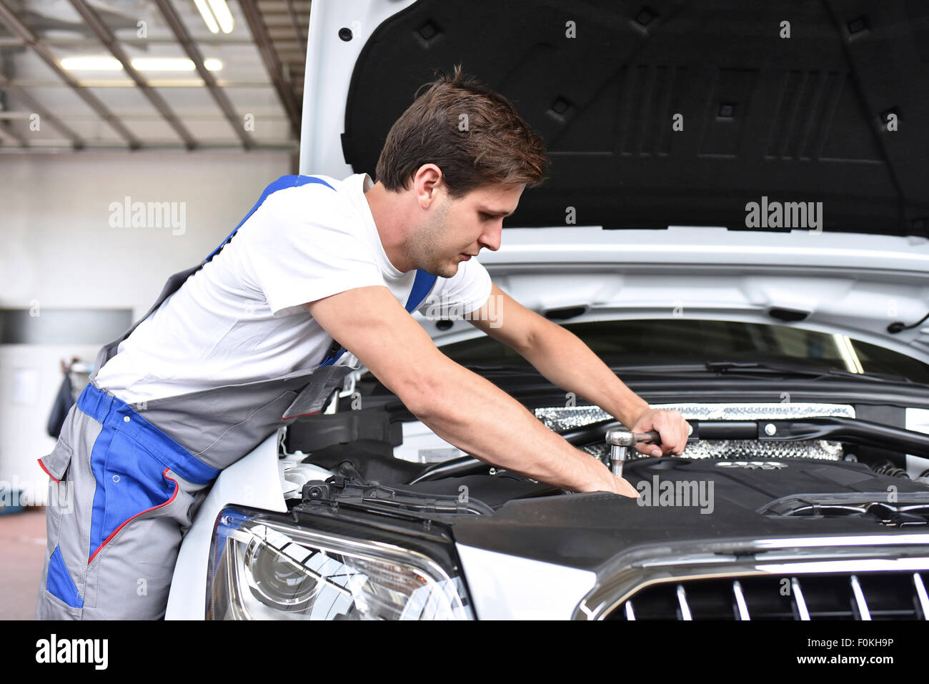 Mechanic repairing car in a garage Stock Photo - Alamy