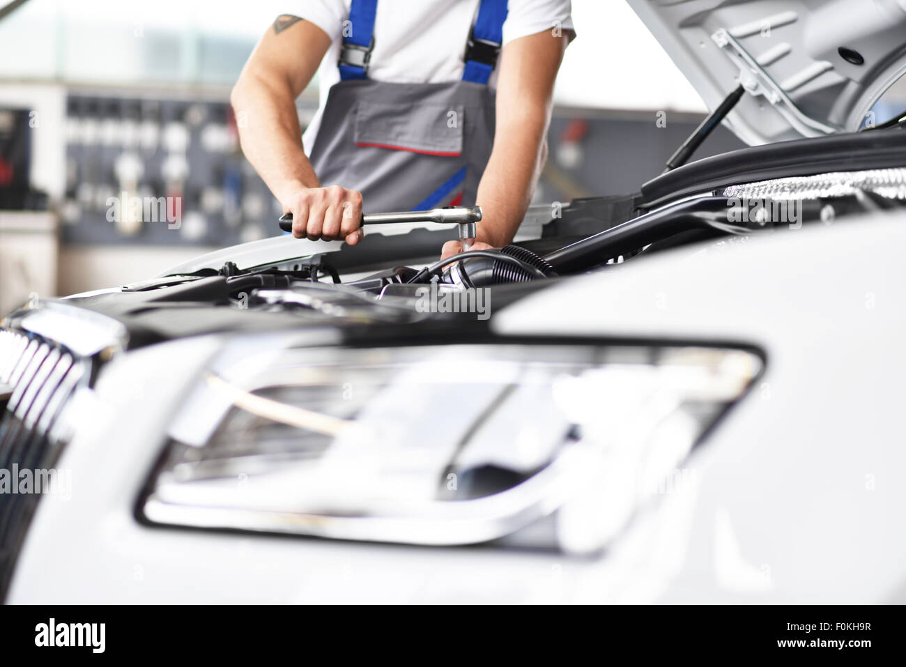Mechanic repairing car in a garage Stock Photo - Alamy
