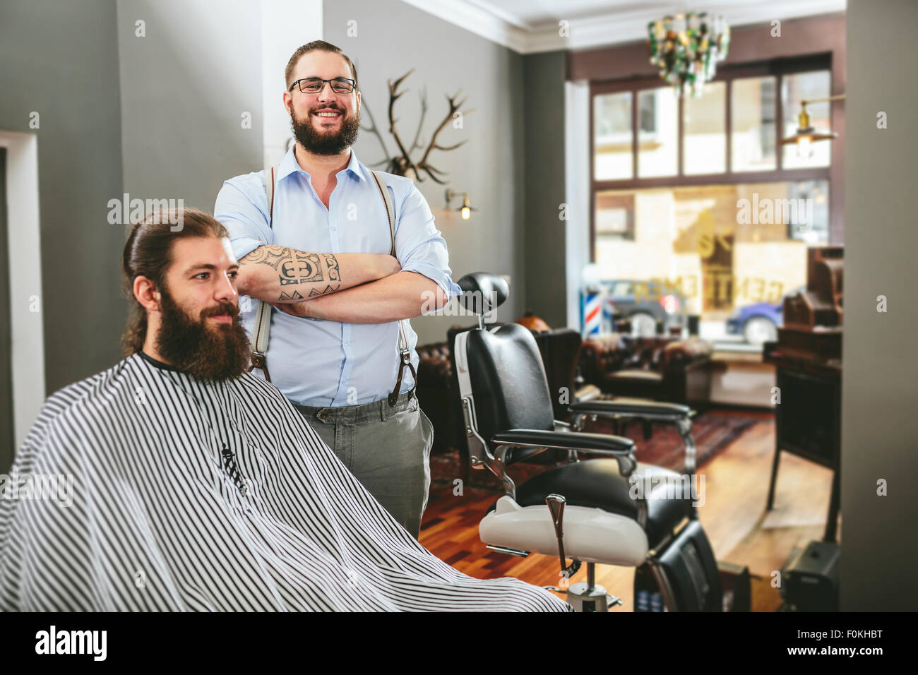Portrait of smiling barber with customer in barber shop Stock Photo - Alamy