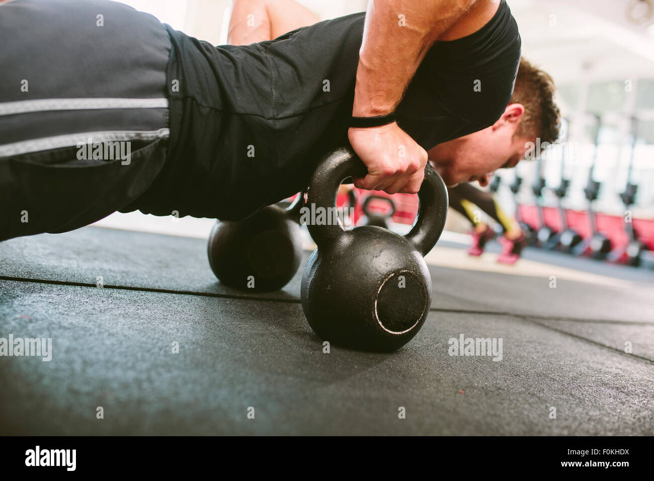 CrossFit athlete doing push-ups on kettlebells Stock Photo