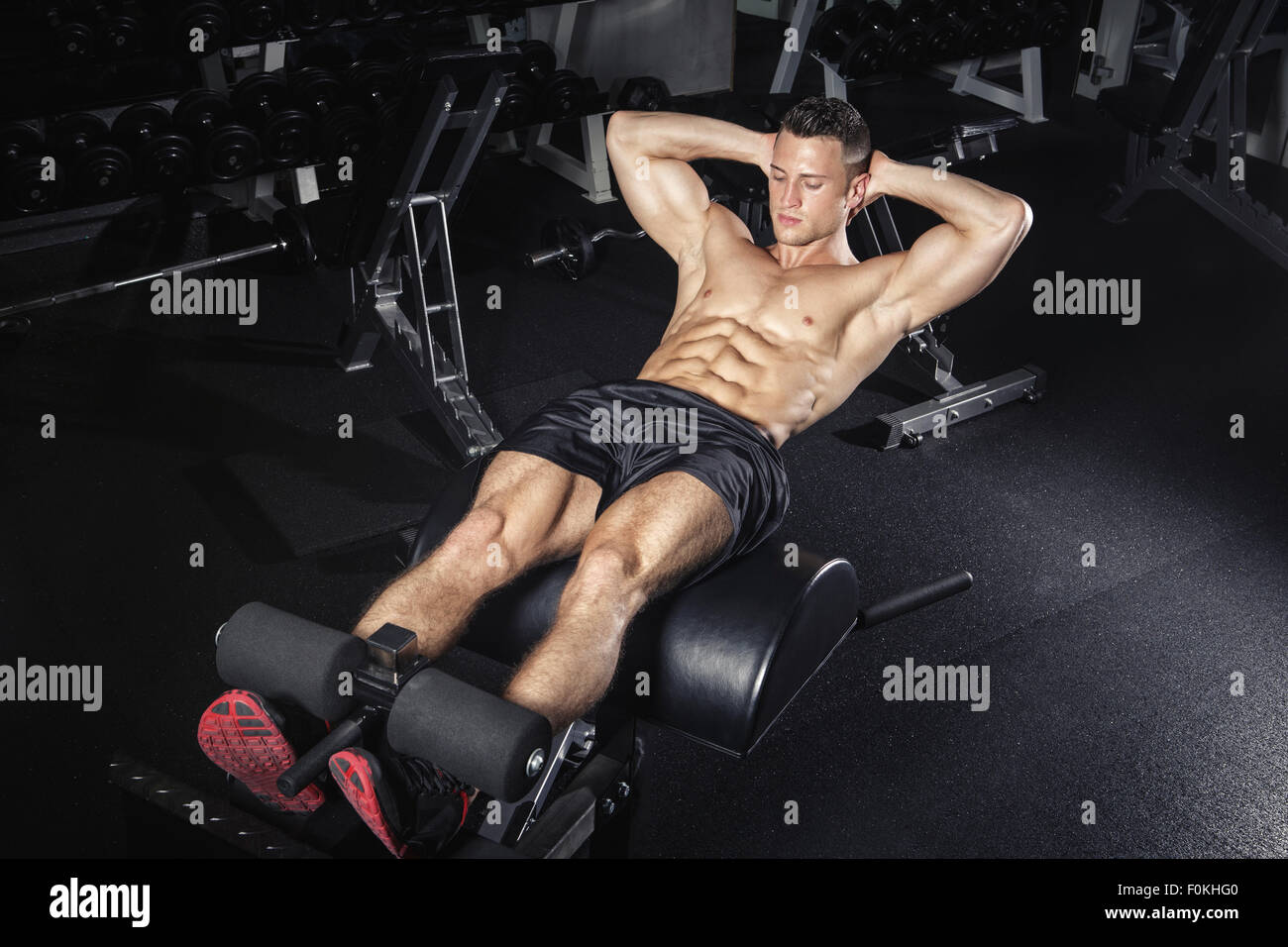 Physical athlete exercising with glute ham developer Stock Photo