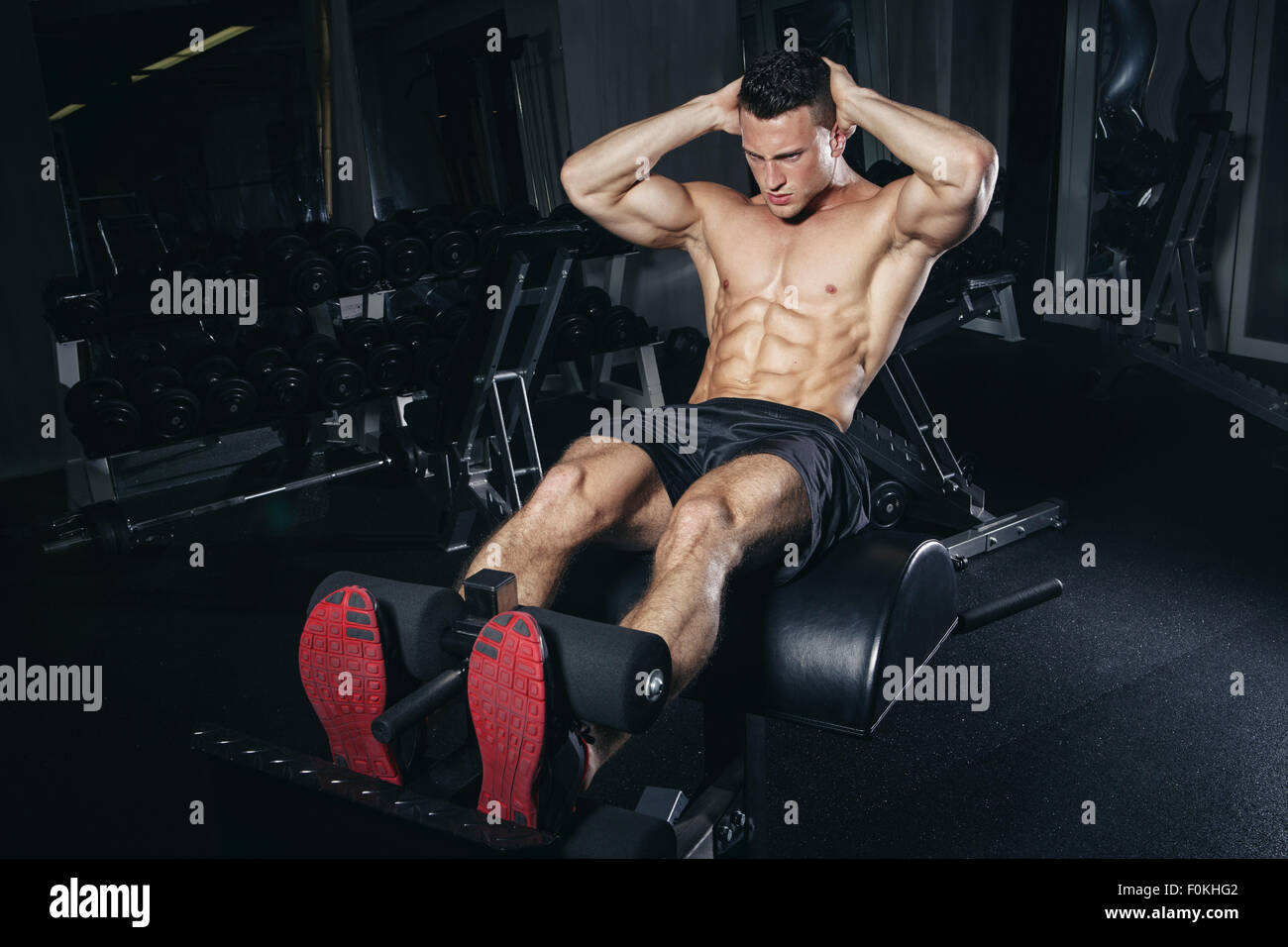 Physical athlete exercising with glute ham developer Stock Photo