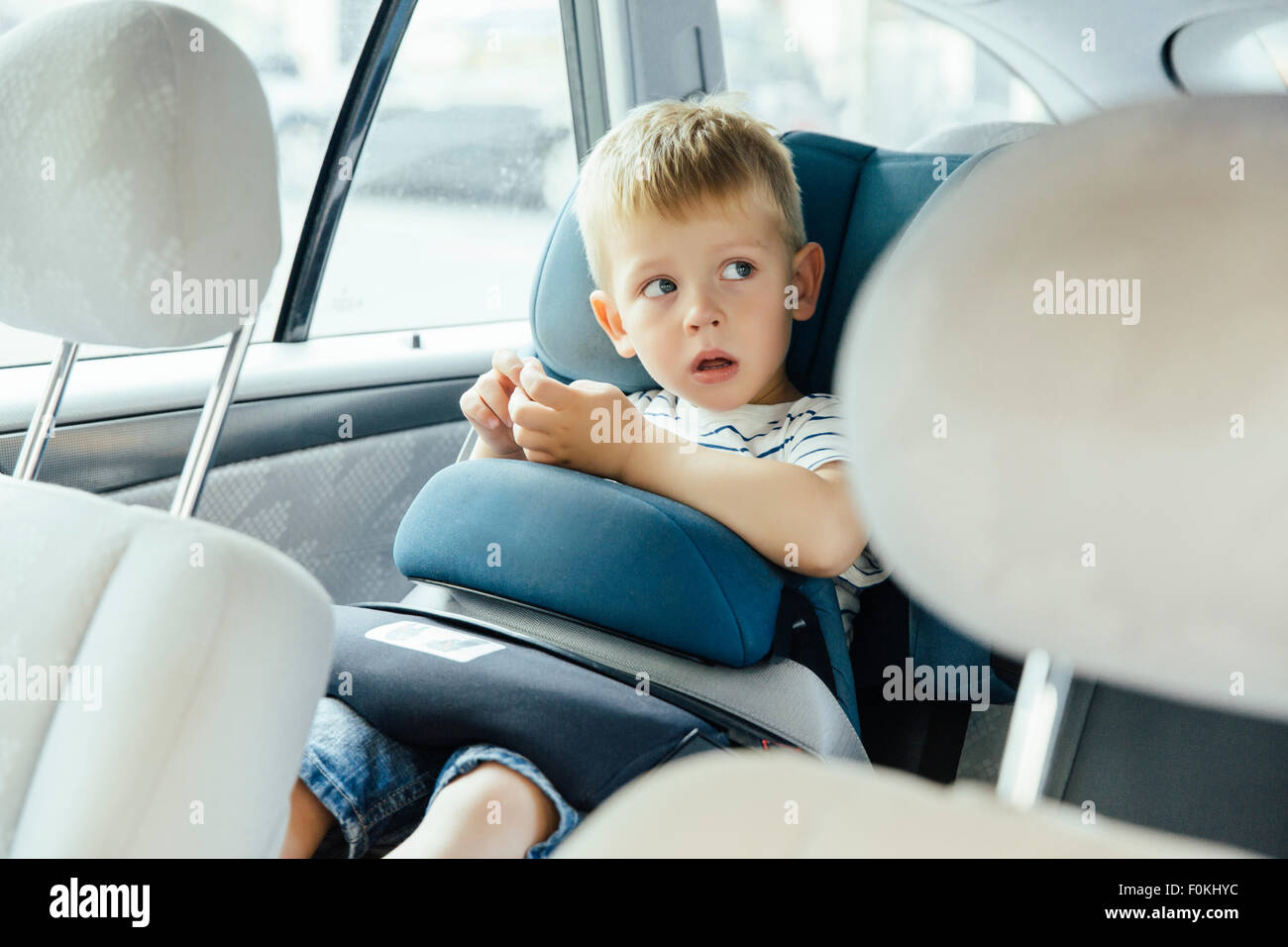 Portrait of little boy sitting in his car seat Stock Photo - Alamy