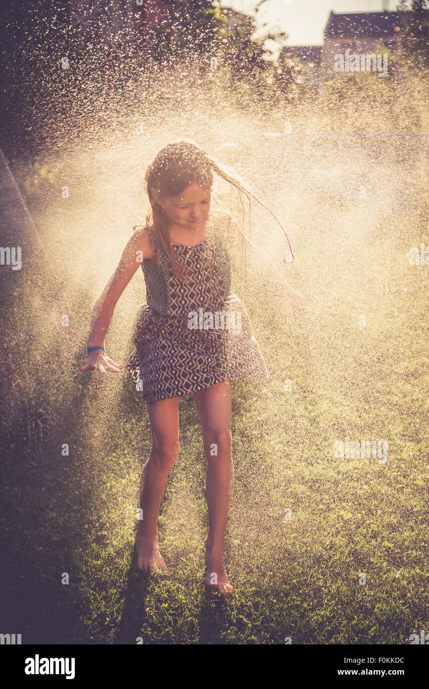 Girl having fun with splashing water in the garden Stock Photo - Alamy