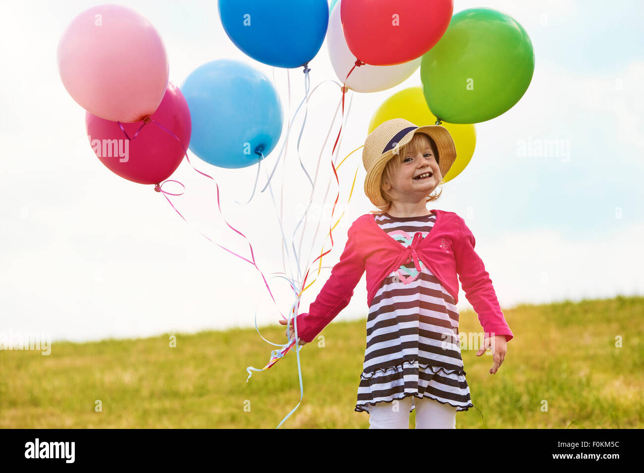 Little girl with balloons on a meadow Stock Photo - Alamy