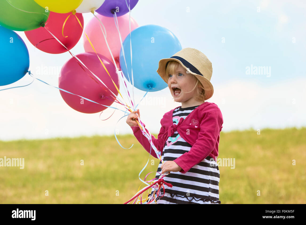 Little girl with balloons on a meadow Stock Photo - Alamy