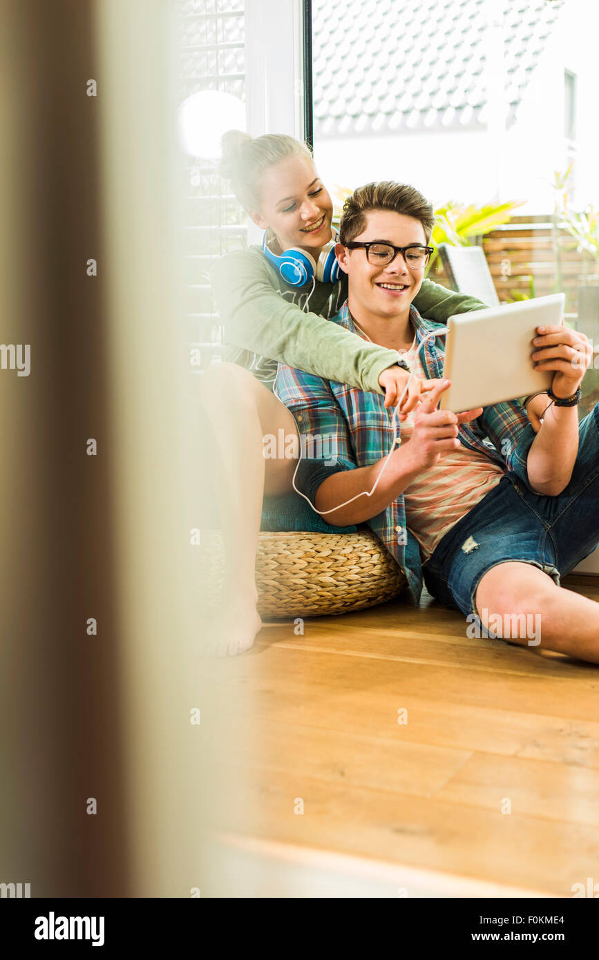 Happy young couple at home sharing digital tablet Stock Photo - Alamy