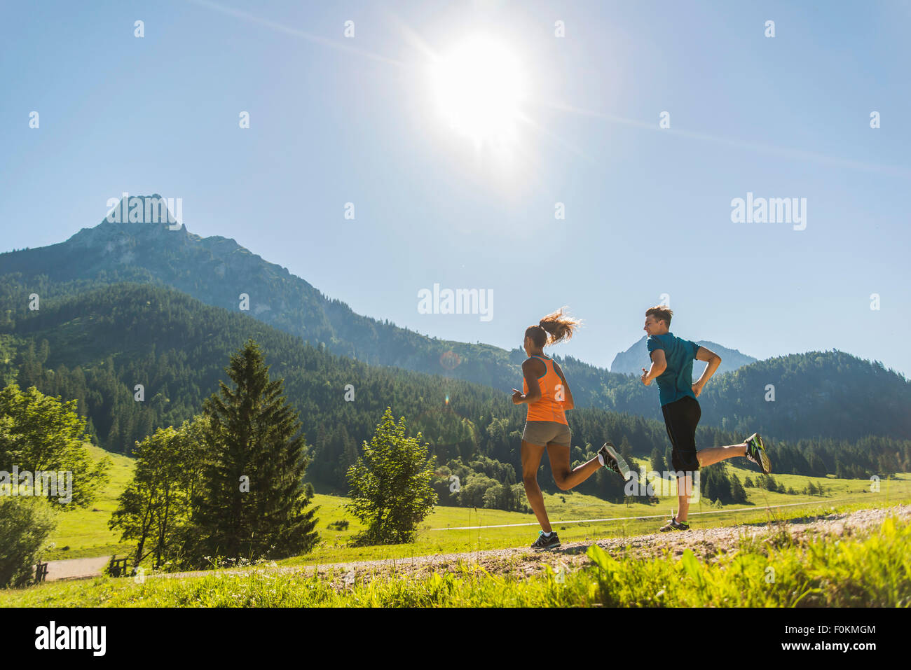 Austria, Tyrol, Tannheim Valley, young couple jogging in alpine landscape Stock Photo