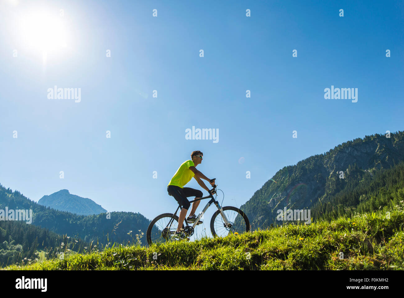 Austria, Tyrol, Tannheim Valley, young man on mountain bike in alpine landscape Stock Photo