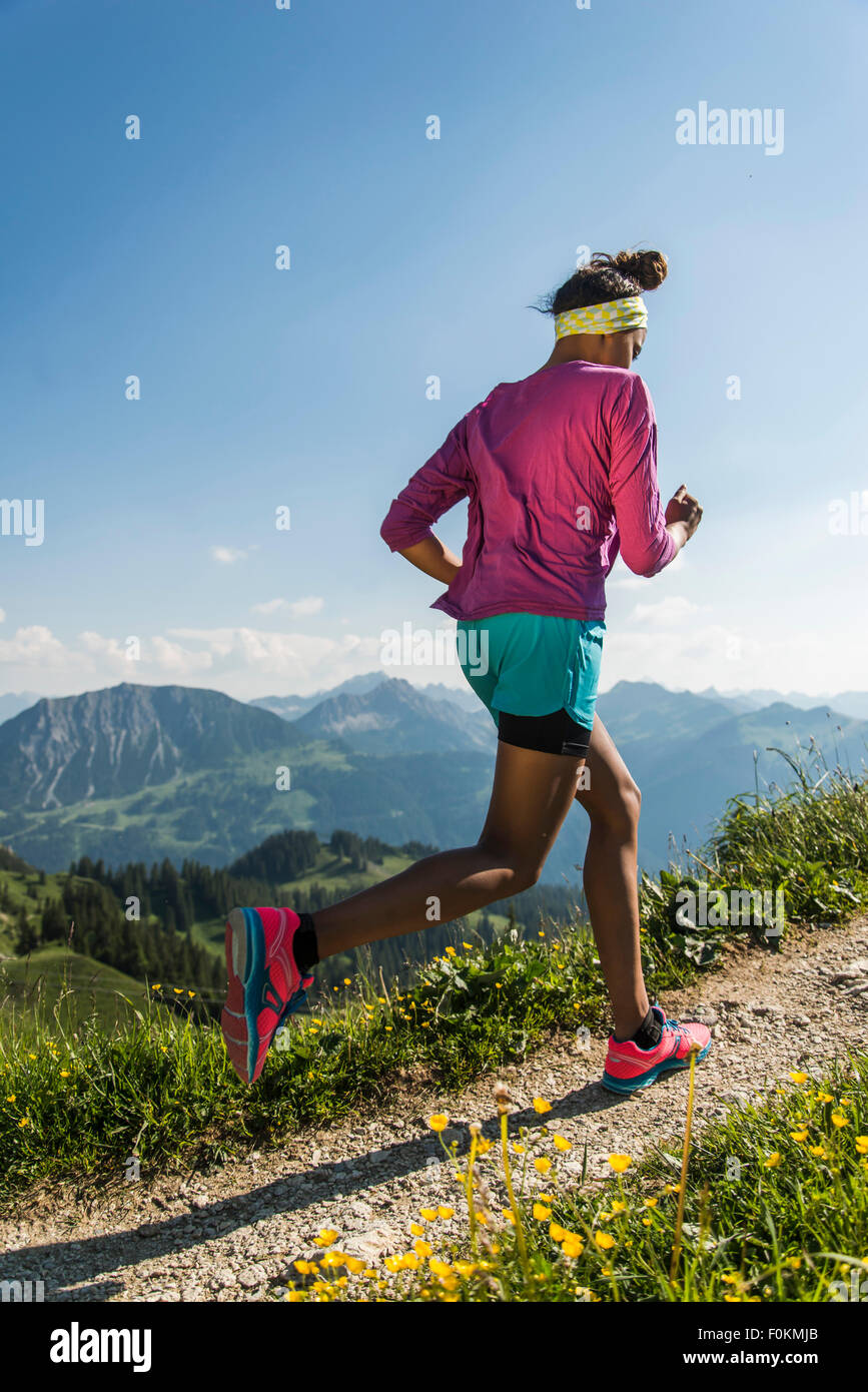 Austria, Tyrol, Tannheim Valley, young woman jogging in mountains Stock Photo