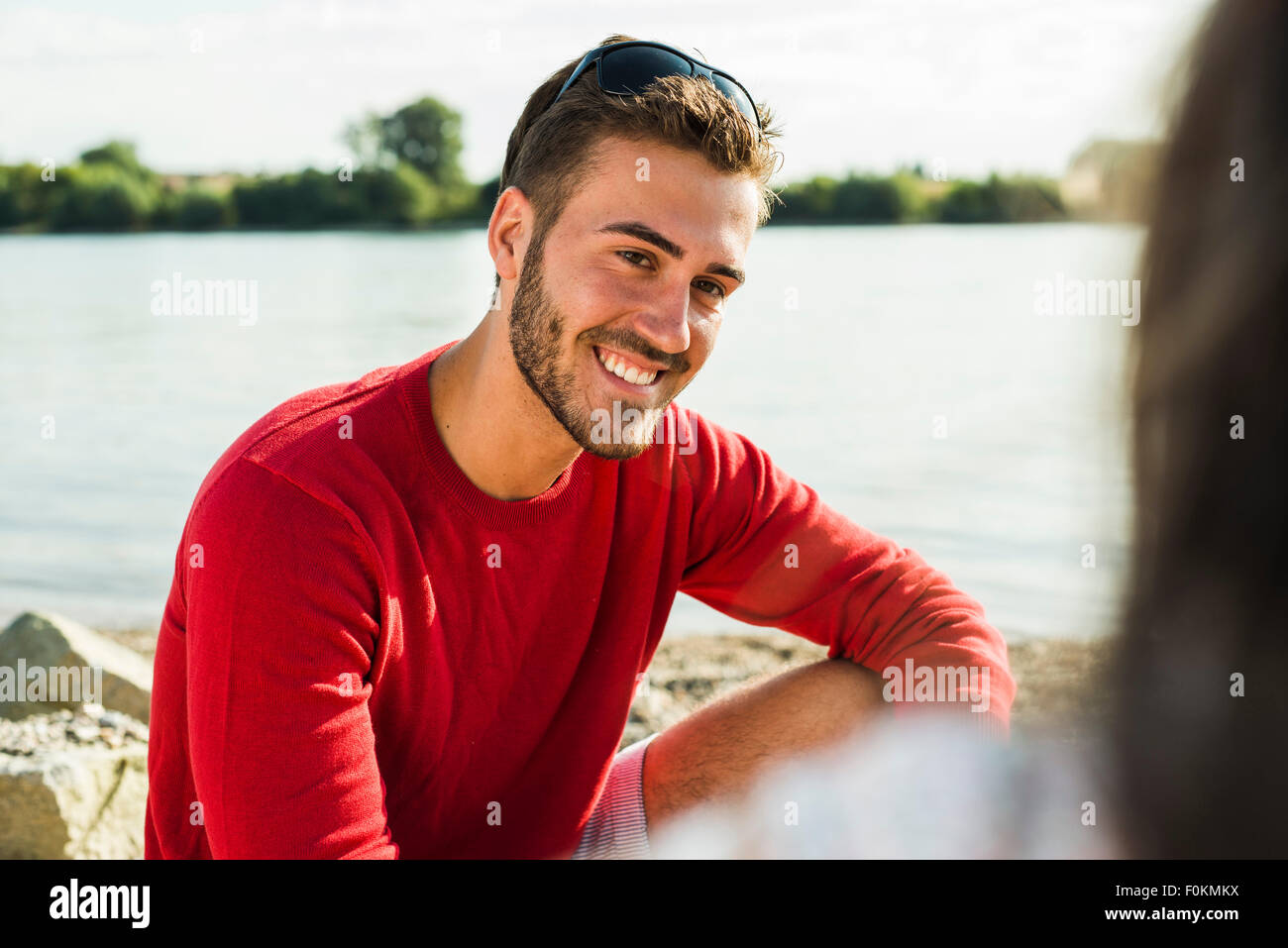 Young man smiling at woman by the riverside Stock Photo