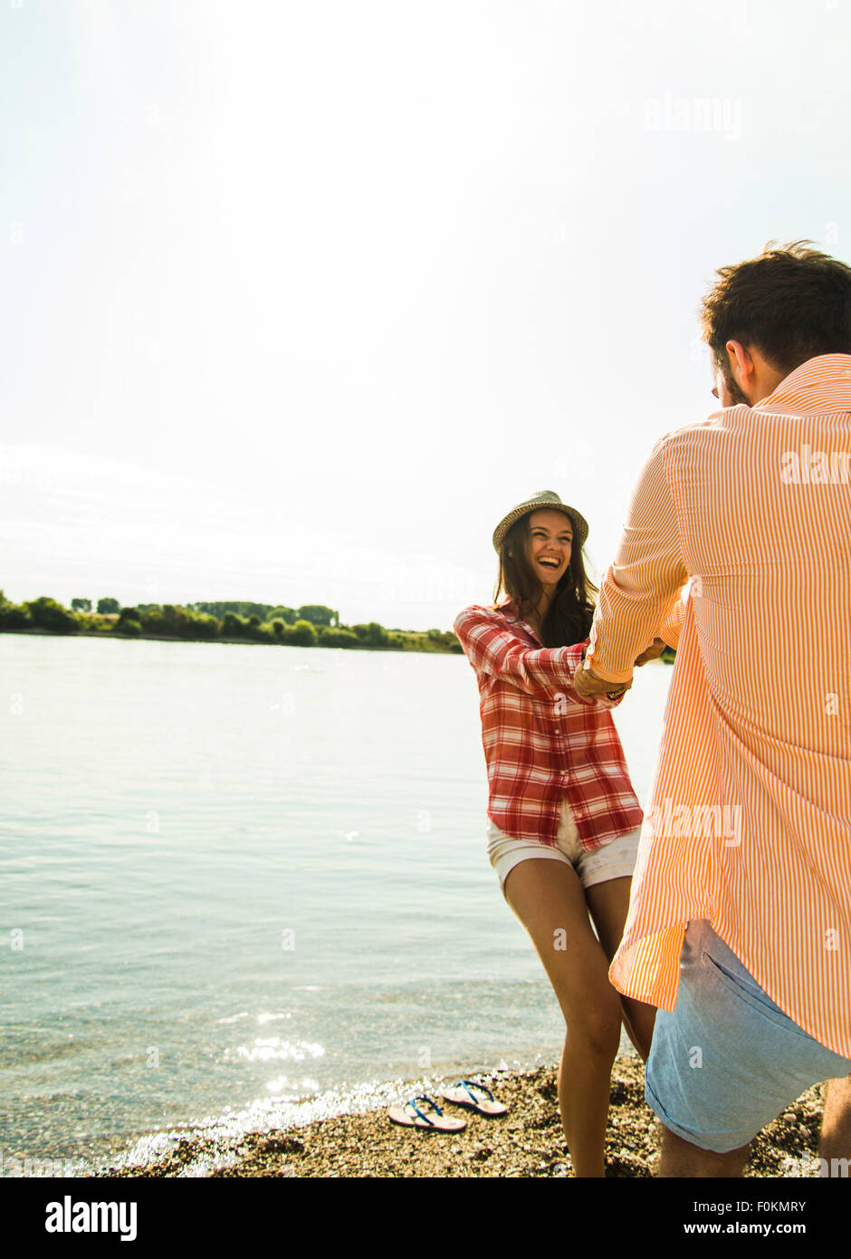 Carefree young couple hand in hand by the riverside Stock Photo